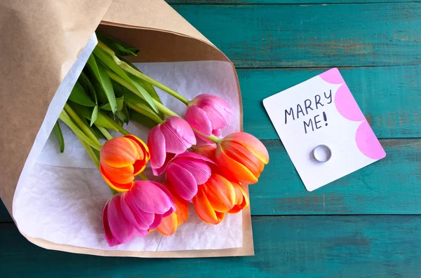 Casa-me nota de mensagem com anel de noivado e buquê de flores — Fotografia de Stock