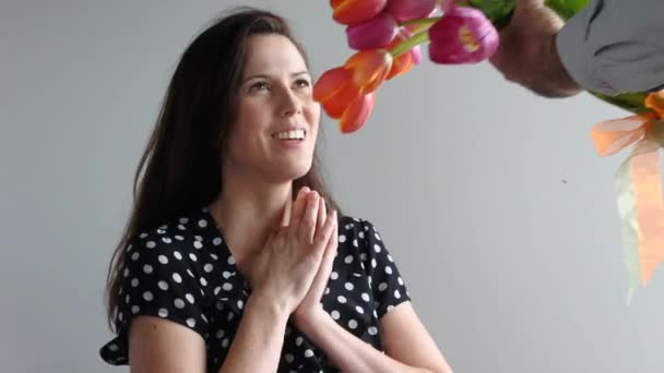 Έκπληκτος γυναίκα λαμβάνει λουλούδια τουλίπα από τον εραστή της — Αρχείο Βίντεο
