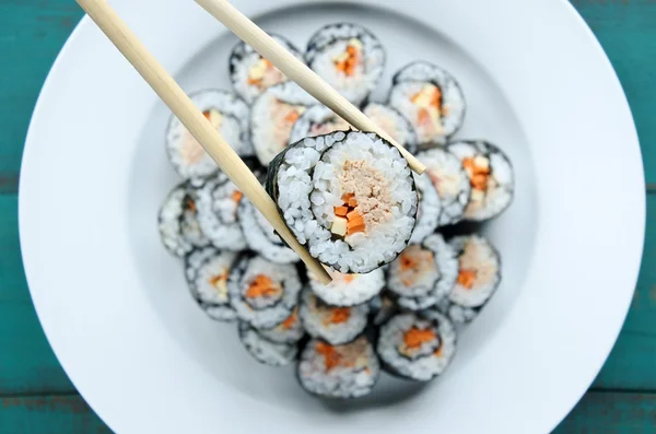 Zblízka hůlky drží sushi maki gunkan roll — Stock fotografie
