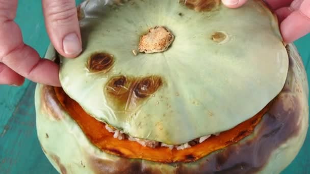 Woman hands opens stuffed pumpkin with rice and mince — Stock Video