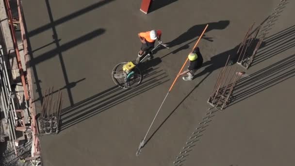 Trabajadores de obras de construcción alisado y capa de cemento nivel — Vídeos de Stock