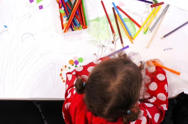 Flat lay view of little girl drawing with colours on a piece of — Stock Photo, Image