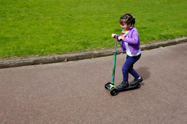 Küçük kız çocuk bir scooter binmek — Stok fotoğraf