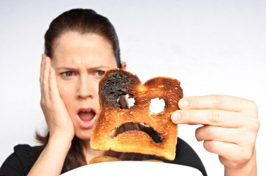 Shock woman holds a burnt slice of toast clipart