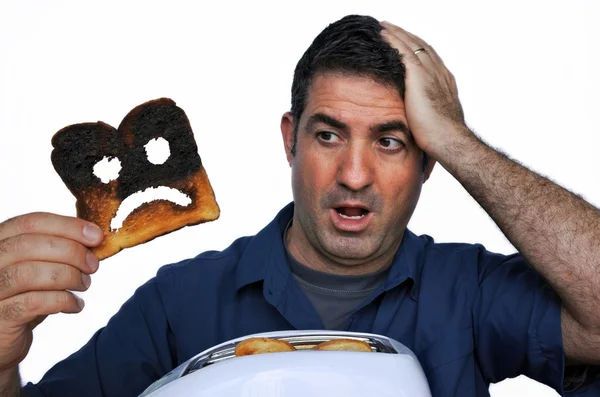 Shock man holds a burnt slice of toast — Stock Photo, Image