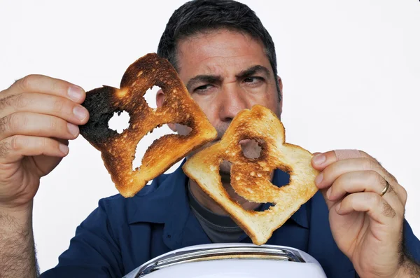 Man looks at two different slices of toast bread — Stock Photo, Image