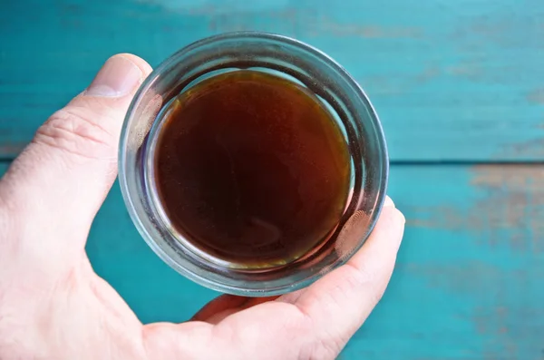 Vista superior de la mano del hombre sostiene una taza de café negro — Foto de Stock