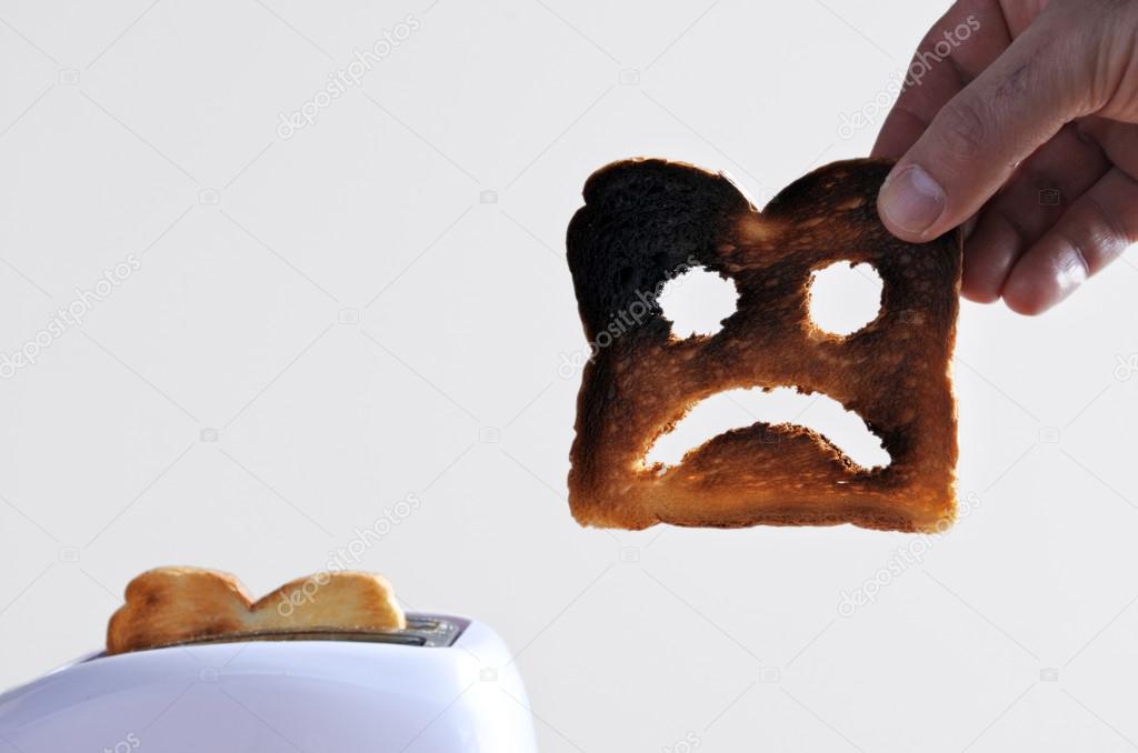 Hand holds one slices of burnt toast 