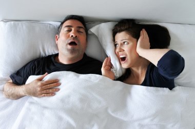 Woman suffers from her partner snoring in bed clipart