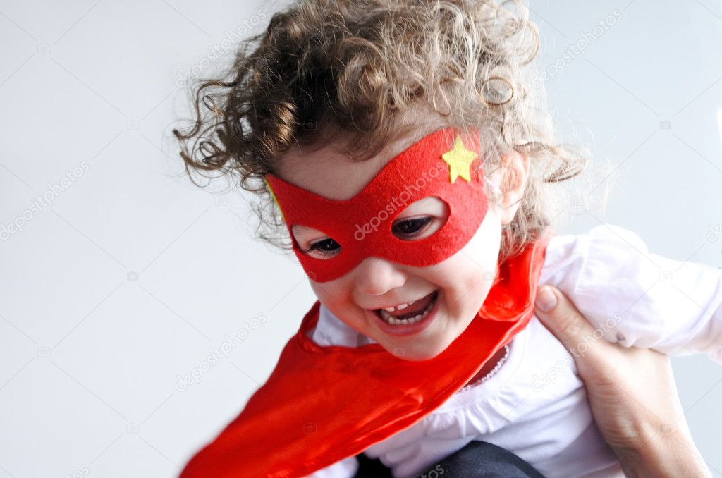 Mother plays with little superhero child (girl age 2-3).  concept photo of Super hero, girl power, plays pretend, childhood, imagination. Real people  copy space