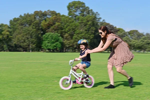 Desfoque Movimento Uma Jovem Mãe Ensinando Filha Andar Bicicleta Grama — Fotografia de Stock