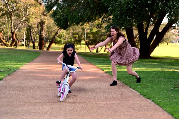 Young Mother Screaming While Her Daughter Riding Bike Wearing Helmet — Stock Photo, Image