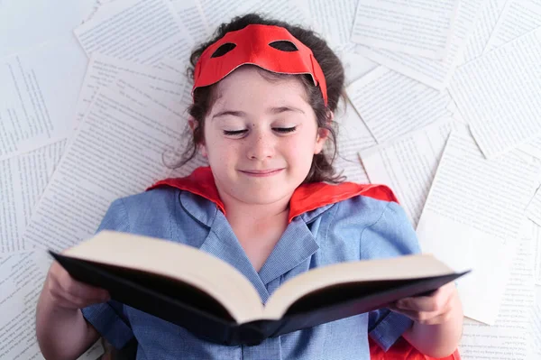 年轻的超级英雄女孩 06岁 在看书 教育概念 真正的人复制空间 — 图库照片