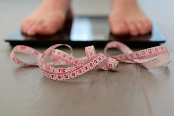 体重計で自分自身を測定若い大人の女性 — ストック写真
