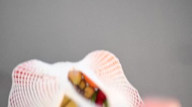 Kadın elleri mutfak tezgahına alışveriş torbası koyuyor.