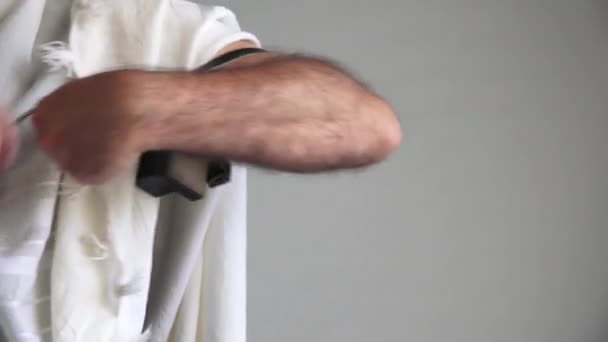 朝の祈りの前に腕テフィラテフィリン文字を身に着けているユダヤ人の男 — ストック動画