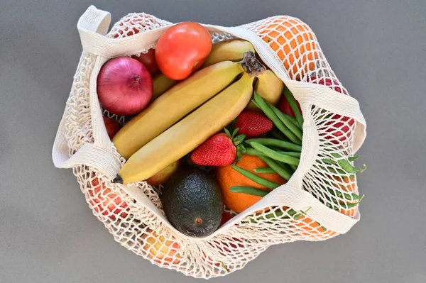 Frau Stellt Einkaufstasche Voller Gemüse Und Obst Auf Heimischen Küchentisch — Stockfoto