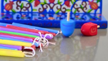 Hanuka Menorah şamdanı, Dreidels (dönen top) ve renkli mumlar tatil arka planı.