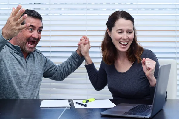 興奮した大人のカップル 40歳 ラップトップ上で肯定的な財務データを見る手を握っています — ストック写真