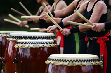 Bir grup Taiko 'lu davulcu Japon davullarını birlikte çalıyor..