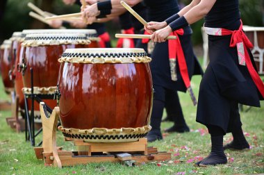 Bir grup Taiko 'lu davulcu Japon davullarını birlikte çalıyor..
