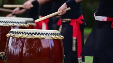 Bir grup Taiko 'lu davulcu Japon davullarını birlikte çalıyor..