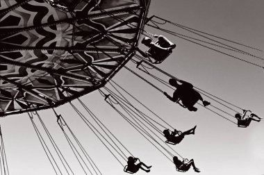 Lunaparkta dönen salıncaklı atlıkarıncaya binen insanların silueti. Düşük ve geniş açılı görüş..
