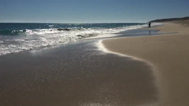 Guilderton, Batı Avustralya 'da kumlu bir sahilde balık tutan aktif kıdemli balıkçıların silueti.