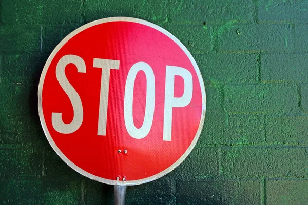 Nagy Piros Közlekedési Stop Tábla Támaszkodik Zöld Téglafal — Stock Fotó