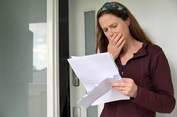 Chockad Vuxen Kvinna Läser Ett Brev Utanför Ytterdörr — Stockfoto