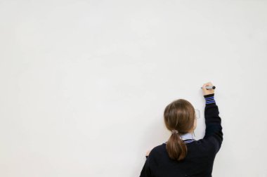 Kopya metni için beyaz tahtaya yazı yazan orta sınıf lise öğrencisinin arka görünümü.