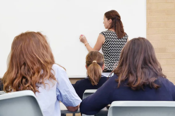 Lkokul Öğretmeninin Öğrencilerle Birlikte Sınıftaki Açık Bir Tahtaya Yazı Yazışının — Stok fotoğraf