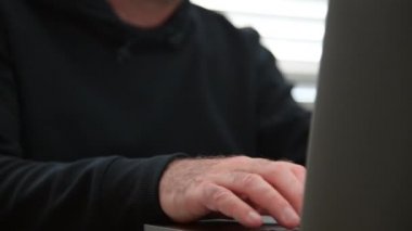 Dizüstü bilgisayarda porno izleyen bir adam kendine dokunuyor..