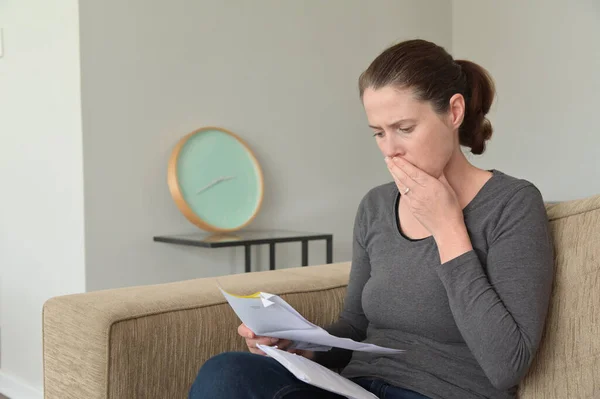 ショックを受けた大人の女 30歳 40歳 自宅の居間で手紙を読む — ストック写真