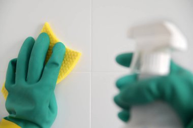 Koruyucu plastik eldiven giyen birinin POV (kişisel bakış açısı) temizlik malzemesi ve süngerle banyo kuyruklarını temizler.