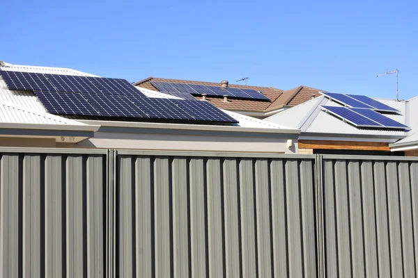 Modern houses with solar panels on rooftops on a clear sky sunny day.