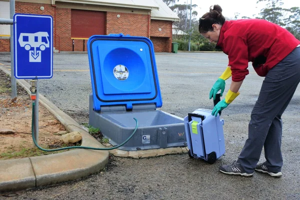 Mujer Australiana Vaciando Tanque Caravana Inodoro Casete Vertedero Durante Viaje Imágenes de stock libres de derechos