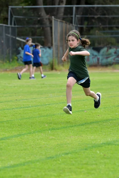 軟弱少女 女性年齢07 野外走路芝生の上でリレーレースを走る — ストック写真