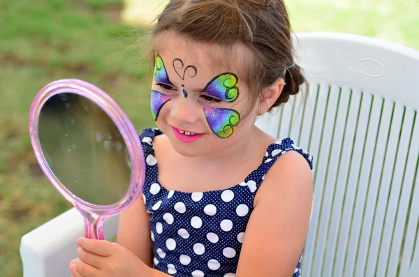 Little girl getting her face painted — Stock Photo, Image