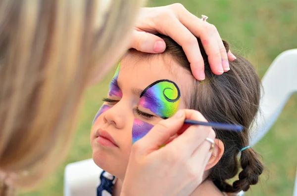 Little girl getting her face painted — Stock Photo, Image