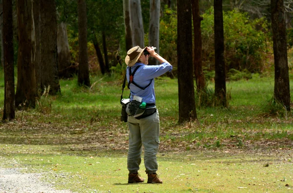 Donna matura birdwatching attraverso il binocolo — Foto Stock