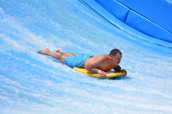 Uomo cavalcare un surf su FlowRider — Foto Stock