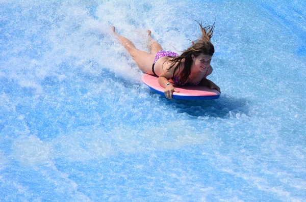 Donna cavalcare un surf su FlowRider — Foto Stock