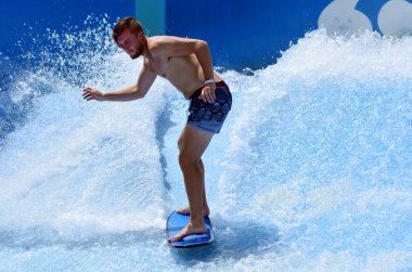 Adam binmek bir sörf tahtası üzerinde Flowrider