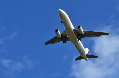 Mavi gökyüzünde uçan ticari uçak