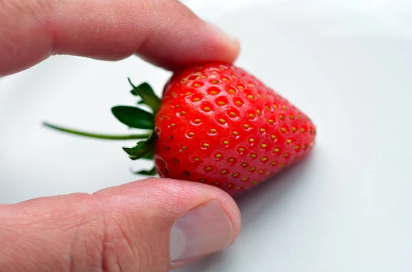 Man hand håller en jordgubbe — Stockfoto