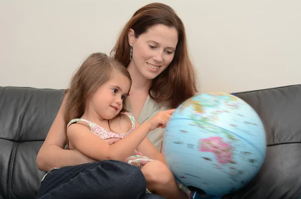 Mãe e filho procuram e examinam o globo — Fotografia de Stock