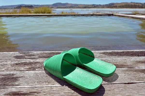Zelené sandály poblíž horké lázně — Stock fotografie