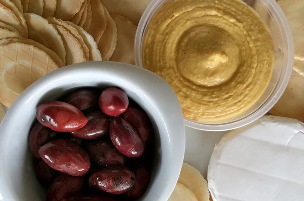 Azeitonas Kalamata, queijo de veia azul, bolachas e húmus — Fotografia de Stock