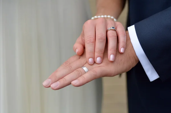 Пара в день свадьбы показывает свои кольца — стоковое фото